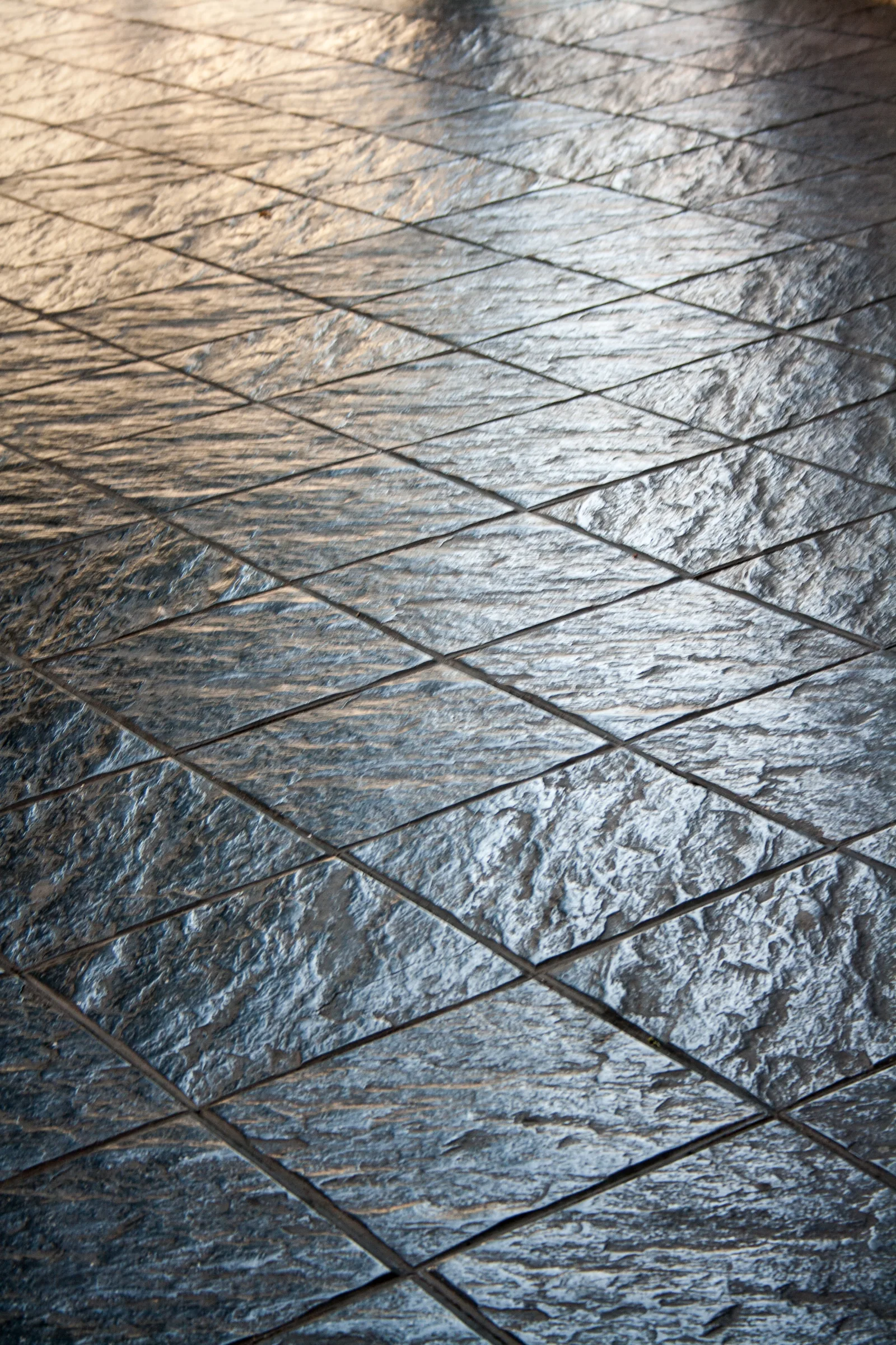 Close-up of a stamped concrete tile pattern showing texture and color detail